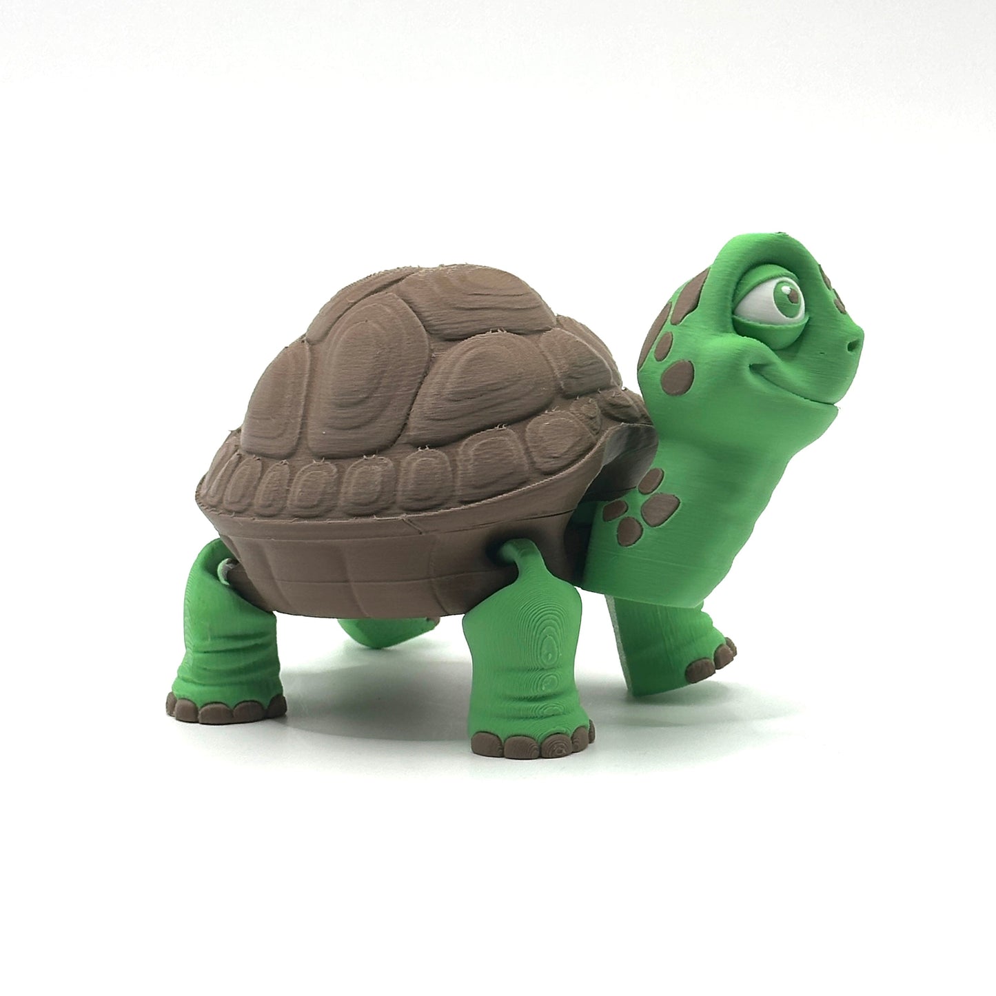Green and brown turtle figurine on a white background