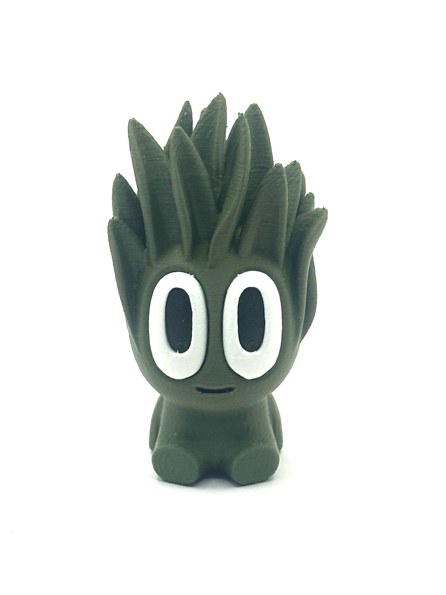 Green cartoon-like figurine with large eyes on a white background