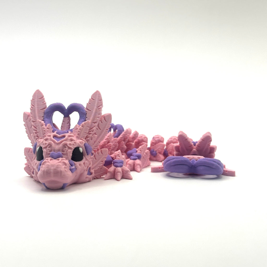 Pink dragon toy with purple accents on a white background