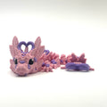Pink dragon toy with purple accents on a white background
