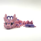 Pink dragon toy with purple accents on a white background
