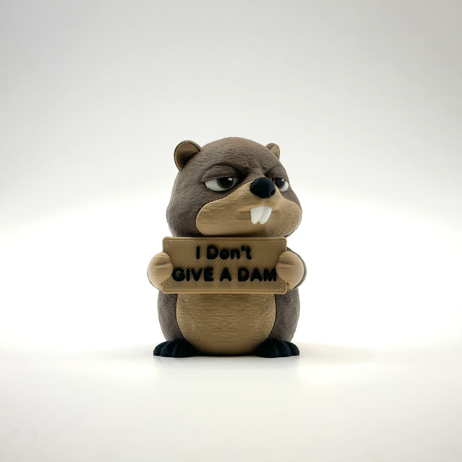 I Don't Give a Dam Beaver 3D printed desk buddy holding its sign, front view